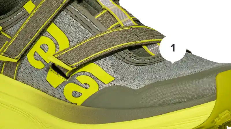 Close-up of a gray and yellow shoe with 'Teva' branding on a white background.